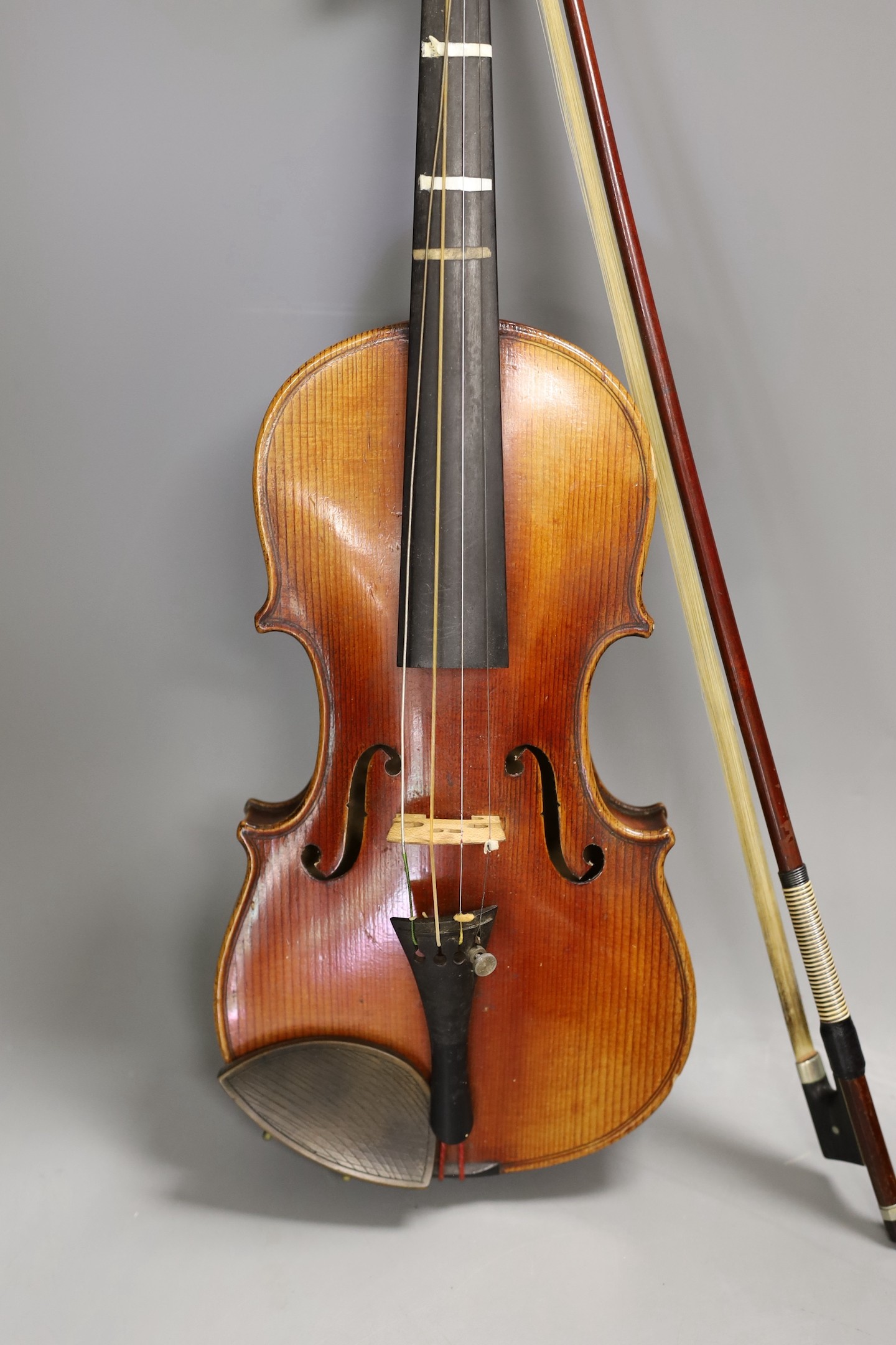 A quarter size late 19th century violin with bow, in E. Hill & Sons case, back measures 29cm